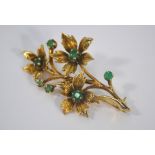 A 9ct yellow gold spray brooch set with seven emeralds