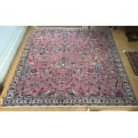 An antique Persian sarouk carpet, the overall floral design on salmon red ground