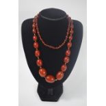 A long row of oval graduated dark red amber beads