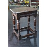 An antique oak joint stool