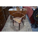 An antique yew and elm Windsor armchair with crinoline stretcher