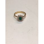 An 18ct yellow gold emerald and diamond cluster ring