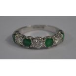 A seven stone emerald and diamond half eternity ring