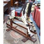 A traditional painted wood rocking horse with leather and horse hair fittings