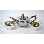 A circular silver three-piece tea service