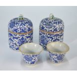 A pair of Chinese blue and white wine cups and lidded warmers with overglaze blue