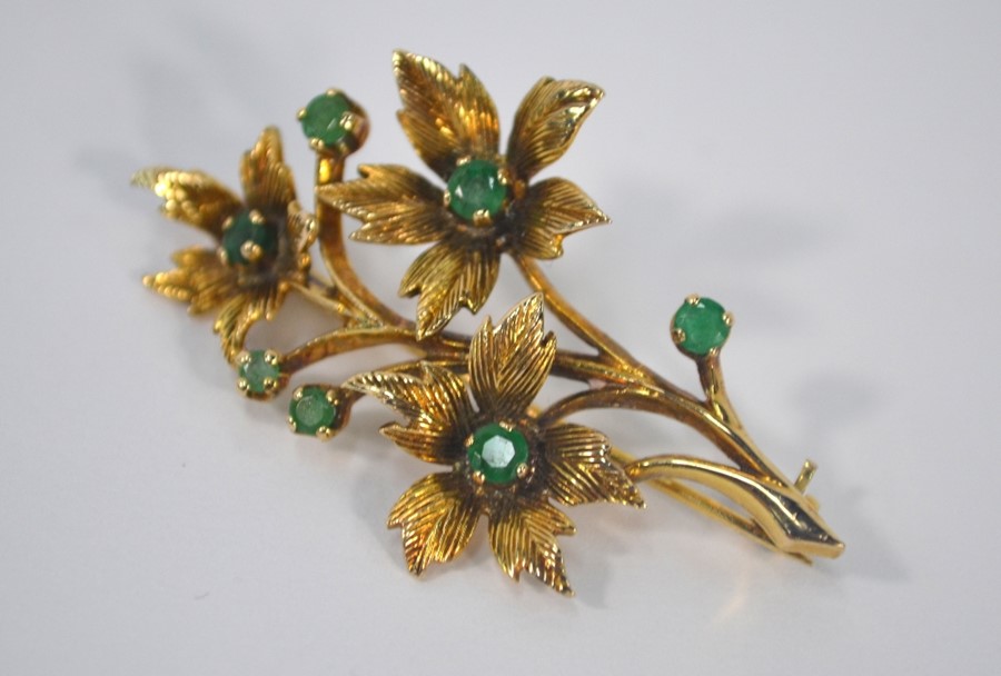 A 9ct yellow gold spray brooch set with seven emeralds