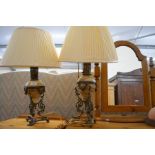 A pair of ornate foliate gilt metal and onyx table lamps with cream pleated shades