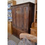 A 19th century panelled oak two section hall cupboard with a single door enclosing a hanging rail