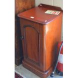 A Victorian mahogany pot cupboard with arch-panelled door enclosing two shelves, raised on a