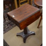 A Victorian mahogany drop-leaf side table with two drawers and opposing dummy drawers on a turned