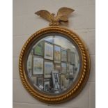 A circular bevelled gilt framed mirror surmounted by an Eagle