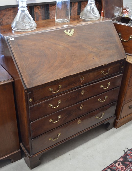 A George III mahogany fall front bureau with fitted interior, four long graduating drawers raised on