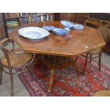 A burr walnut feather-banded and satin strung octagonal dining table with four turned pillar