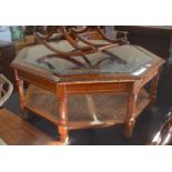 An octagonal glass-top coffee table with caned under tier