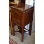 A Victorian mahogany wash stand/commode with twin hinged top, cupboard and single drawer raised on