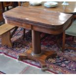 A Victorian rosewood card table with folding baize-lined top raised on a turned column and concave