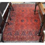 A Persian Turkoman rug with stylised floral design on red ground with repeating border and kelim