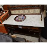 An Edwardian mahogany marble top wash stand with tiled back, two frieze drawers and turned supports