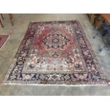 A Persian Heriz small carpet, the geometric design centred by a large medallion on red ground with