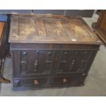 An 18th century and later panelled oak mule chest with hinged top, carved front and single drawer