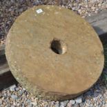 An antique weathered cut stone mill wheel