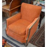 A pair of box shaped arm chairs with carved oak frames and orange upholstery, circa 1920's
