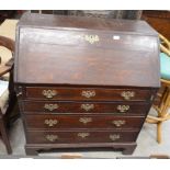 A Georgian oak fall front bureau with fitted interior over four long graduating drawers raised on