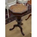 A Victorian mahogany and marquetry octagonal sewing table with tapering column and carved supports