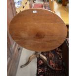 A mahogany and oak occasional table with circular tilt top raised on a turned column and triform