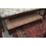 A Regency style overstuffed foot stool with foliate upholstery and short cabriole supports