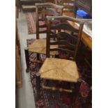 A harlequin set of eight provincial oak ladder back and rush seated dining chairs