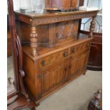 A 17th century style carved oak court cupboard with two drawers and linenfold panelled doors