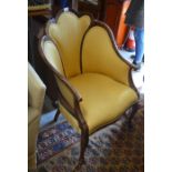 An Edwardian shell-back arm chair with yellow satin upholstery and cabriole front supports