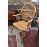 A beech spindle backed and saddle seated Windsor chair with turned supports united by a crinoline