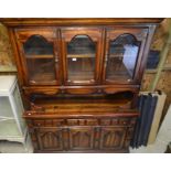 A large American oak display cabinet with glazed doors, three drawers and panelled cupboards