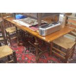 An oak extending dining table with panelled cleated draw-leaf top raised on slender turned