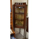 An Edwardian inlaid mahogany corner display cabinet with astragal glazed door, raised on slender