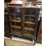A mahogany bookcase with a pair of glazed doors enclosing three shelves, raised on cabriole supports