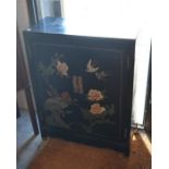 A small Chinese lacquered two door cabinet, painted decoration with rock work, birds and flowering