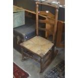 A 19th century ladder back rush seated rocking chair with turned supports and stretchers