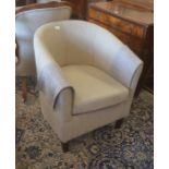 A modern tub chair with light-fawn linen upholstery and square mahogany supports