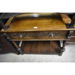 A carved oak hall table with two frieze drawers and turned supports united by a slatted open