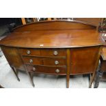An Edwardian mahogany bowfront sideboard with two cupboards and three central drawers raised on
