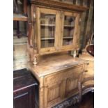 An antique stripped pine dresser cabinet, two glazed in doors over one long drawer and pair of