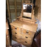 An antique mirror backed stripped and waxed pine dressing chest of two short over two long drawers