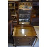 A dark oak mirror back dressing chest with three drawers