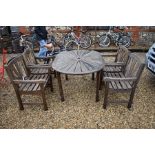 A weathered teak garden dining table to/w a set of four teak garden arm chairs