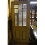 An old panelled stripped pine doors, part glazed with 1930s ribbed glass