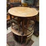 Two circular teak dining tables each with four nesting slat seated chairs